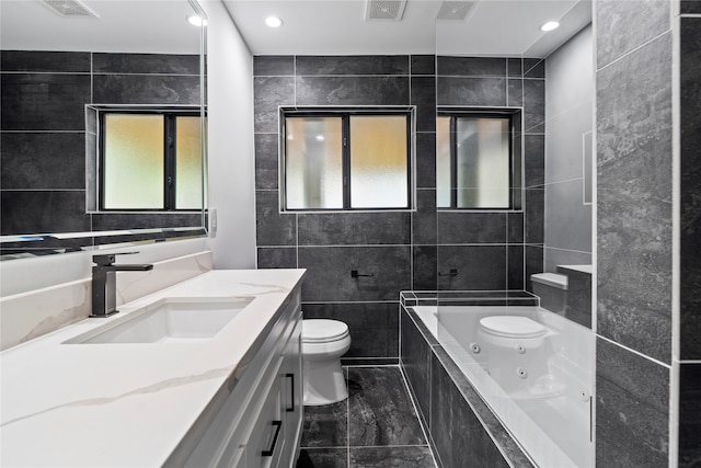 bathroom with vanity, toilet, a relaxing tiled tub, and a healthy amount of sunlight