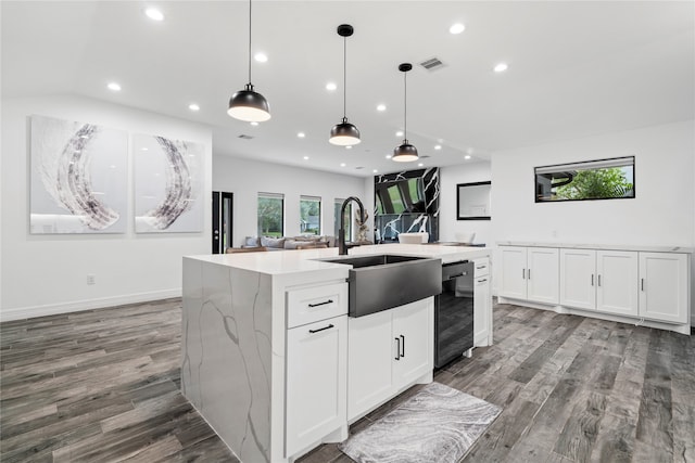 kitchen featuring a kitchen island with sink, white cabinetry, wood-type flooring, and sink