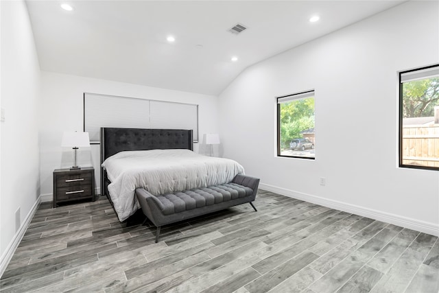 bedroom with lofted ceiling and light hardwood / wood-style floors