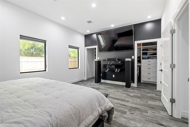 bedroom featuring light hardwood / wood-style flooring, a spacious closet, and a closet