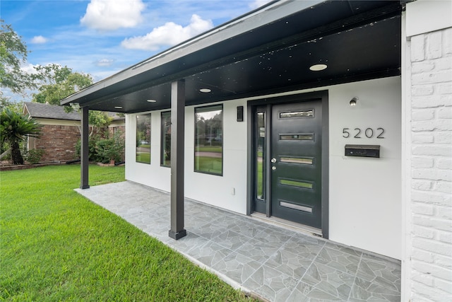 property entrance featuring a lawn