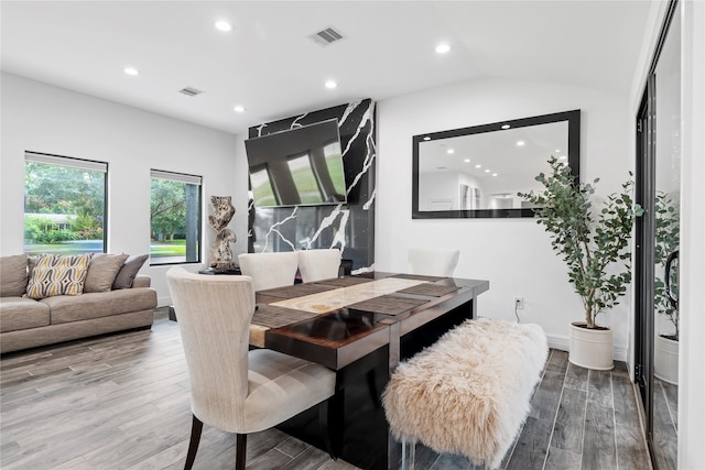 dining area with lofted ceiling and hardwood / wood-style floors