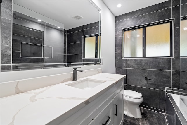 bathroom with vanity, toilet, plenty of natural light, and a washtub