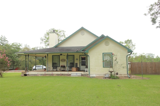 back of property featuring a lawn and ceiling fan