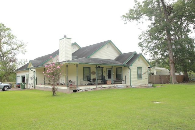 rear view of property featuring a yard and a porch