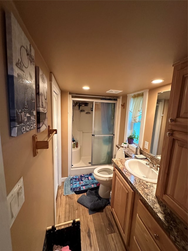 bathroom featuring a shower with door, vanity, toilet, and wood-type flooring