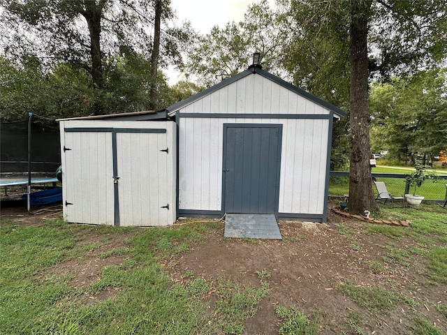 view of outbuilding featuring a yard and a trampoline