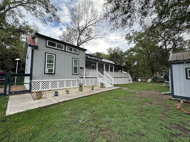 exterior space with a front lawn, a porch, and an outbuilding