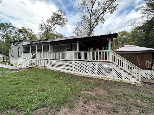 rear view of house with a lawn and covered porch