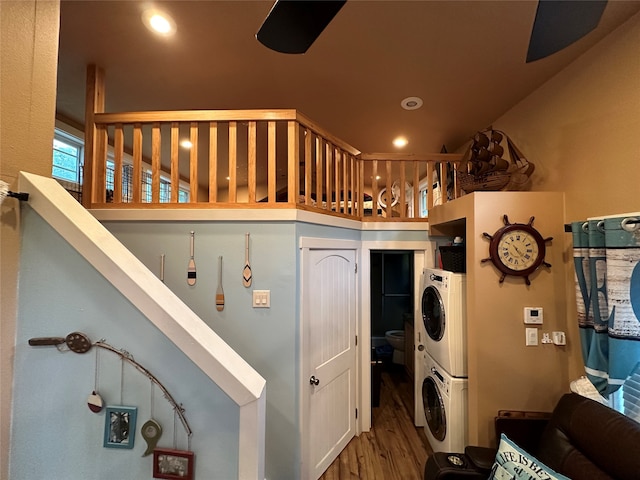 interior space with stacked washer and clothes dryer, ceiling fan, and wood-type flooring