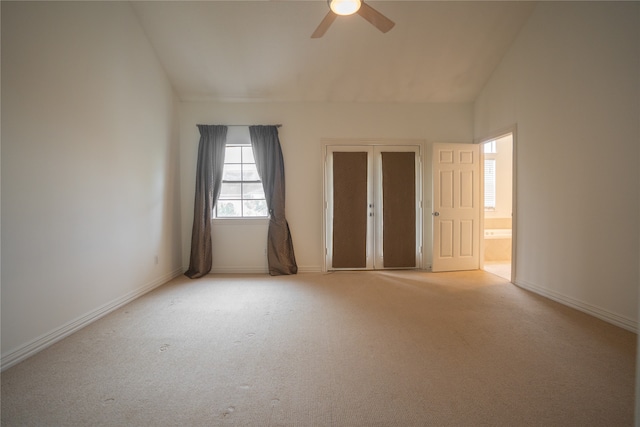 carpeted spare room featuring ceiling fan and vaulted ceiling