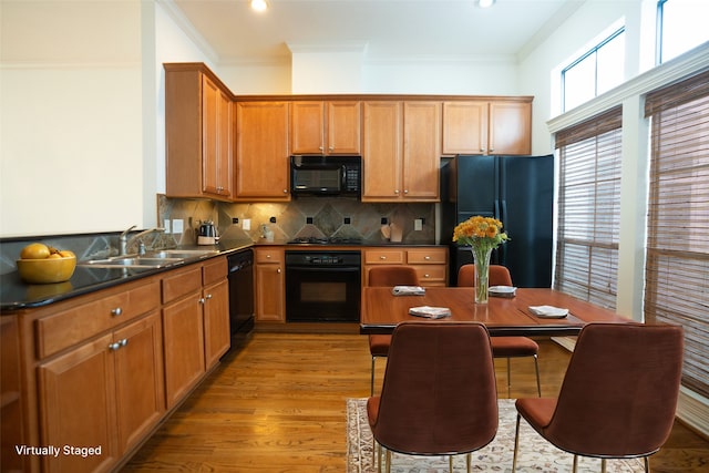 kitchen with sink, black appliances, light hardwood / wood-style flooring, and ornamental molding