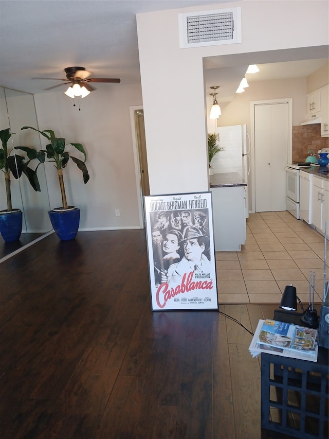 interior space featuring white appliances, ceiling fan, tile patterned floors, and white cabinets