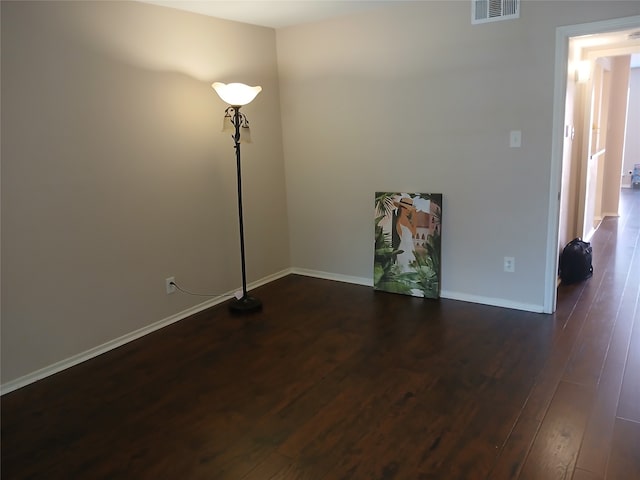 unfurnished room with dark wood-type flooring