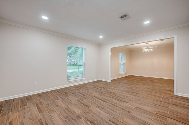 unfurnished room featuring light wood-type flooring, a notable chandelier, and ornamental molding