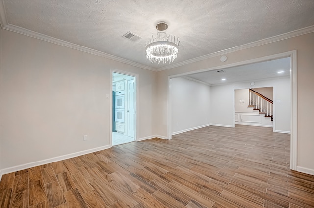 unfurnished room featuring ornamental molding, a textured ceiling, wood-type flooring, and a notable chandelier