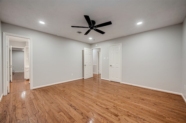 unfurnished bedroom with ensuite bathroom, ceiling fan, and light hardwood / wood-style floors