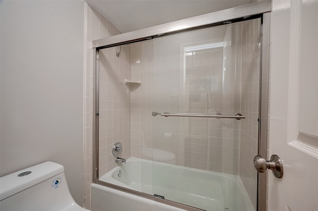 bathroom featuring shower / bath combination with glass door and toilet