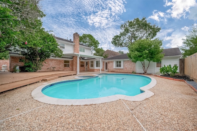 view of swimming pool featuring a patio area and a wooden deck