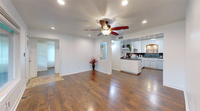 unfurnished living room with ceiling fan, dark hardwood / wood-style floors, and sink