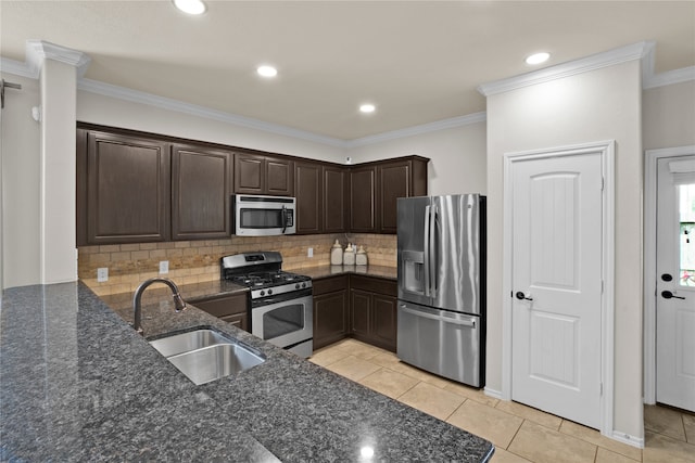 kitchen with decorative backsplash, appliances with stainless steel finishes, dark stone counters, crown molding, and sink