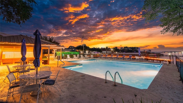 pool at dusk with a patio