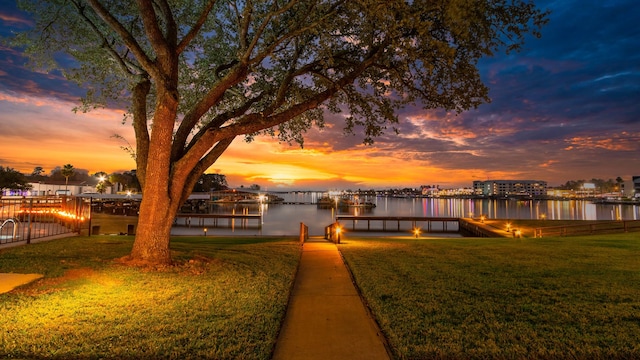 dock area with a yard and a water view