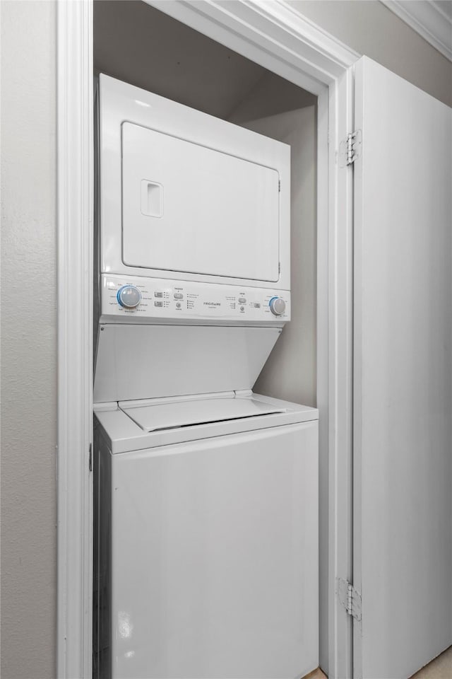 clothes washing area with stacked washer and dryer