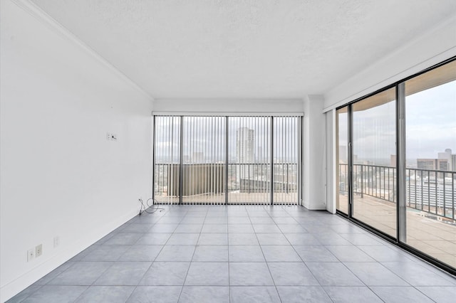 unfurnished room with baseboards, light tile patterned floors, ornamental molding, and a textured ceiling