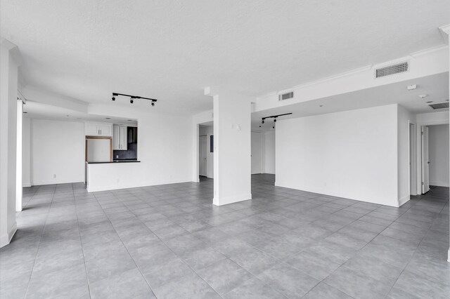 interior space with a textured ceiling and track lighting