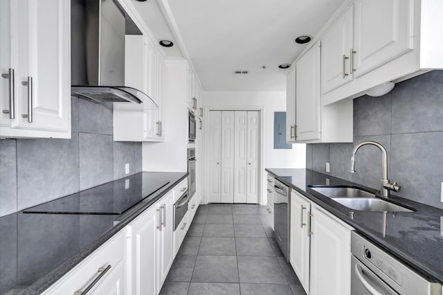 kitchen with white cabinetry, backsplash, a sink, wall chimney range hood, and appliances with stainless steel finishes