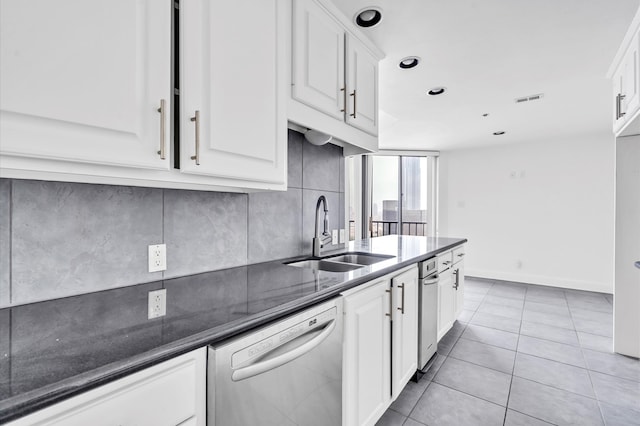 kitchen featuring white cabinets, dishwasher, sink, dark stone counters, and light tile patterned flooring