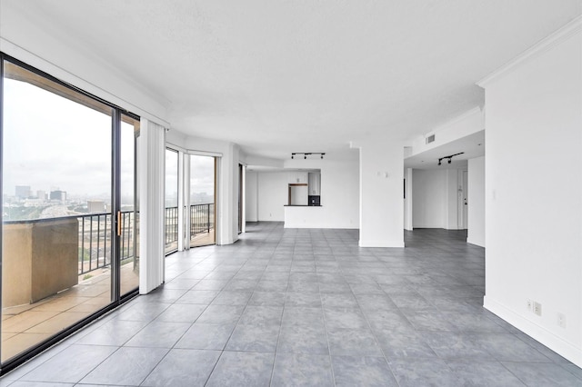 unfurnished living room featuring baseboards, ornamental molding, and visible vents