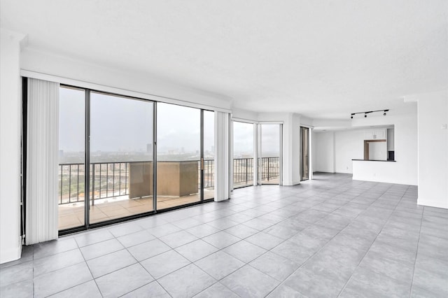 unfurnished living room featuring track lighting