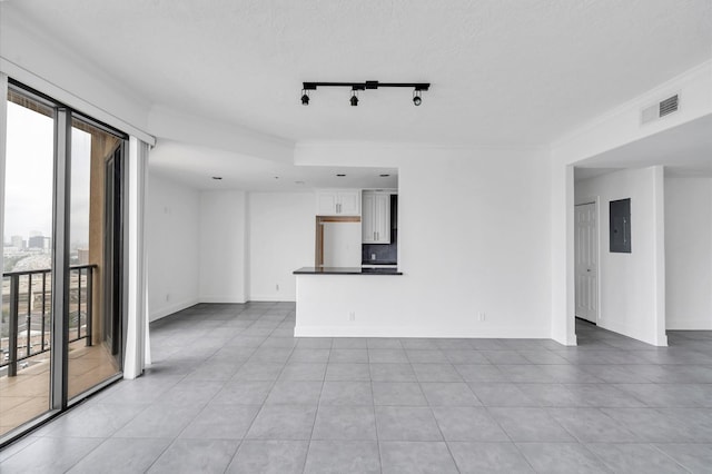 unfurnished living room with baseboards, a textured ceiling, visible vents, and electric panel