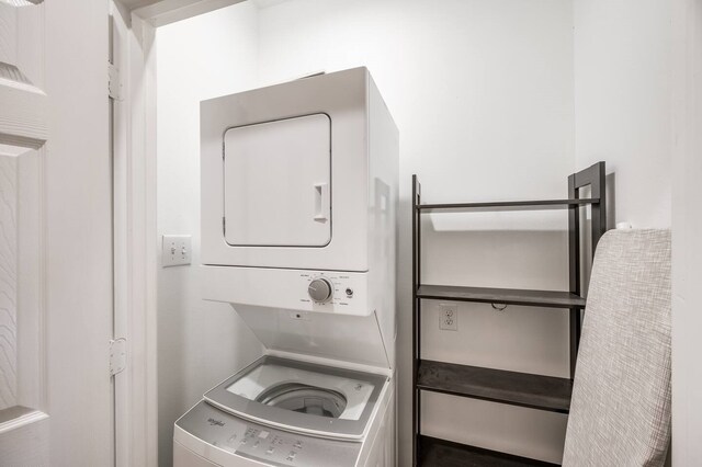 clothes washing area featuring stacked washer and dryer