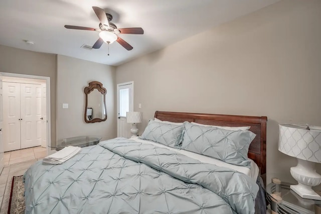 bedroom with light tile patterned flooring, ceiling fan, and a closet