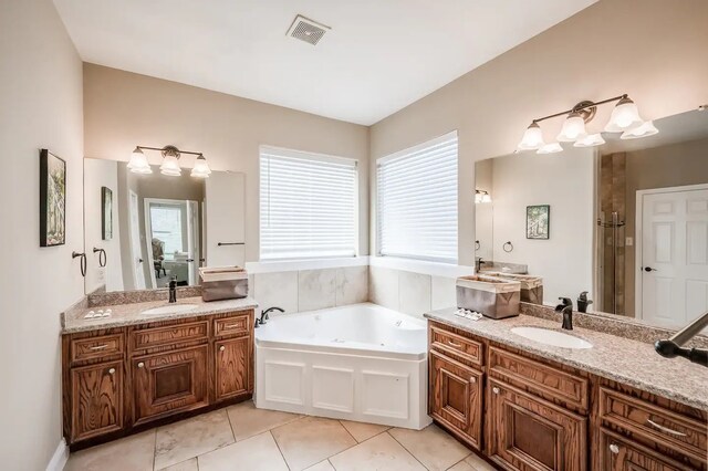 bathroom with tile patterned flooring, a bathtub, and vanity