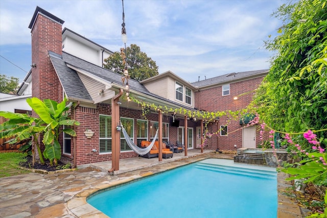 view of pool with a patio area and an in ground hot tub