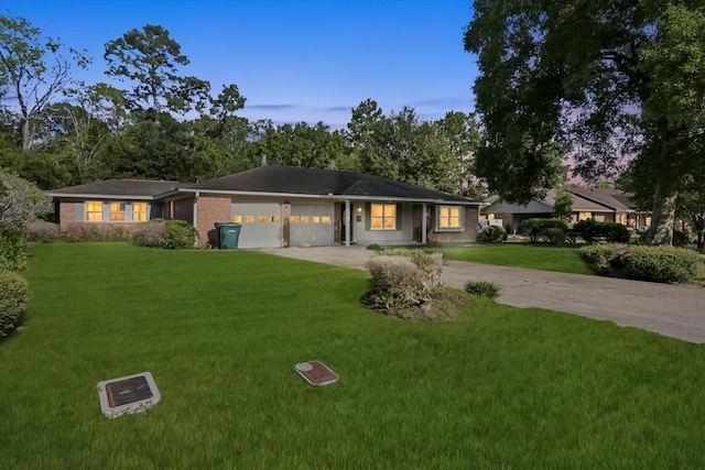 ranch-style home featuring a lawn and a garage