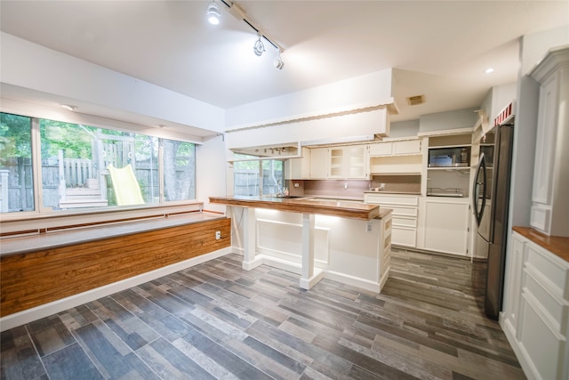 kitchen featuring stainless steel fridge, dark hardwood / wood-style flooring, butcher block countertops, and white cabinets