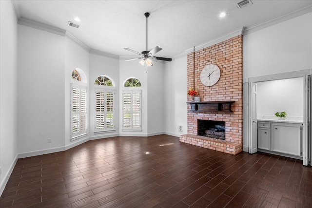 unfurnished living room featuring a fireplace, crown molding, ceiling fan, and dark hardwood / wood-style floors