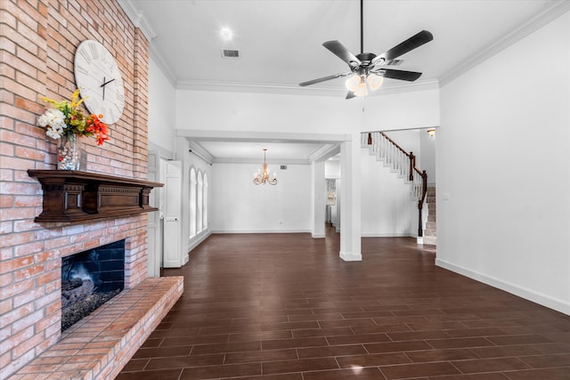 unfurnished living room featuring crown molding, ceiling fan with notable chandelier, a brick fireplace, and dark hardwood / wood-style flooring