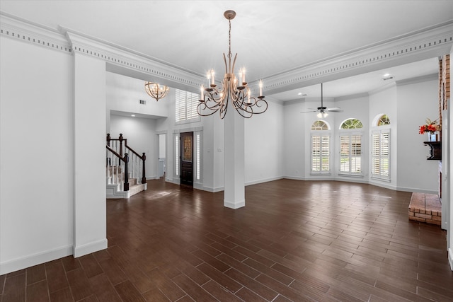 interior space featuring ornamental molding, ceiling fan with notable chandelier, and dark hardwood / wood-style flooring