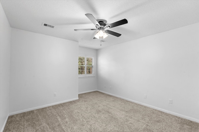 spare room featuring light carpet, a textured ceiling, and ceiling fan