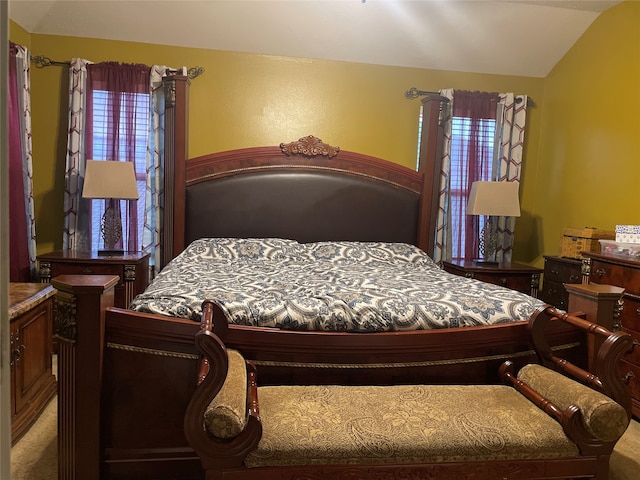 carpeted bedroom featuring multiple windows and lofted ceiling