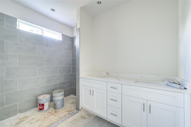 bathroom featuring vanity and tile walls