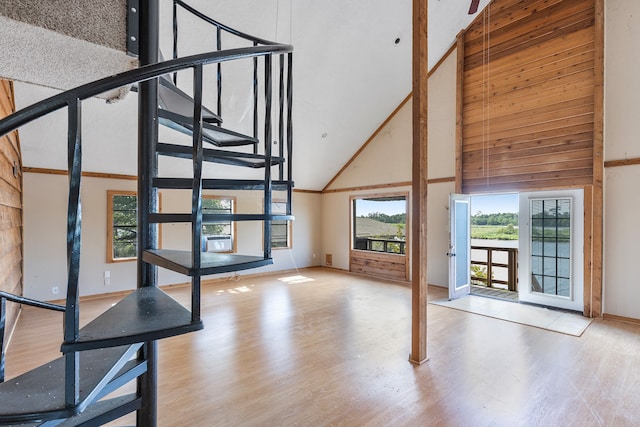 unfurnished living room with high vaulted ceiling and light hardwood / wood-style flooring