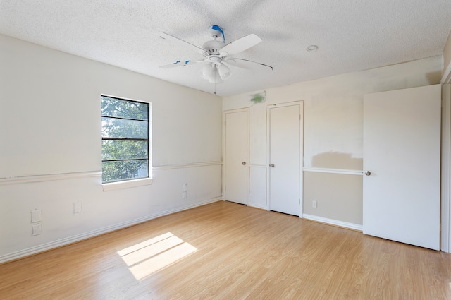 unfurnished bedroom featuring light wood-type flooring, a textured ceiling, and ceiling fan