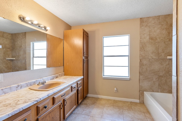 bathroom with vanity, a textured ceiling, a wealth of natural light, and tile patterned flooring